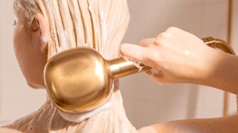 Woman with long blonde hair using gold canopy showerhead.