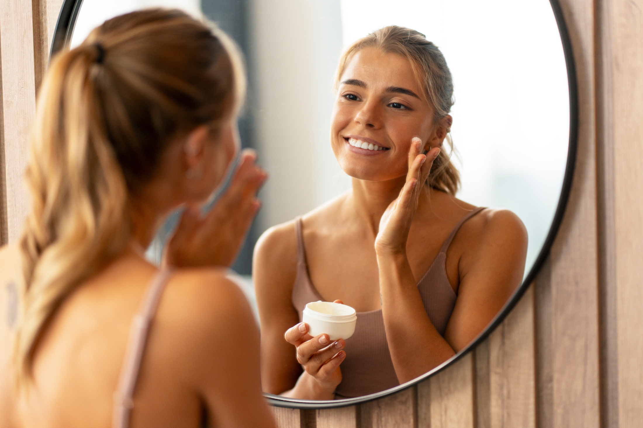 Beautiful Woman In Mirror Applying Facial Skin Cream Adobe Stock 680584299