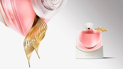 The crystal bottle rests on a pristine white ceramic base, adorned with Lancôme’s signature rose agora pattern in gold, evoking a precious jewel.