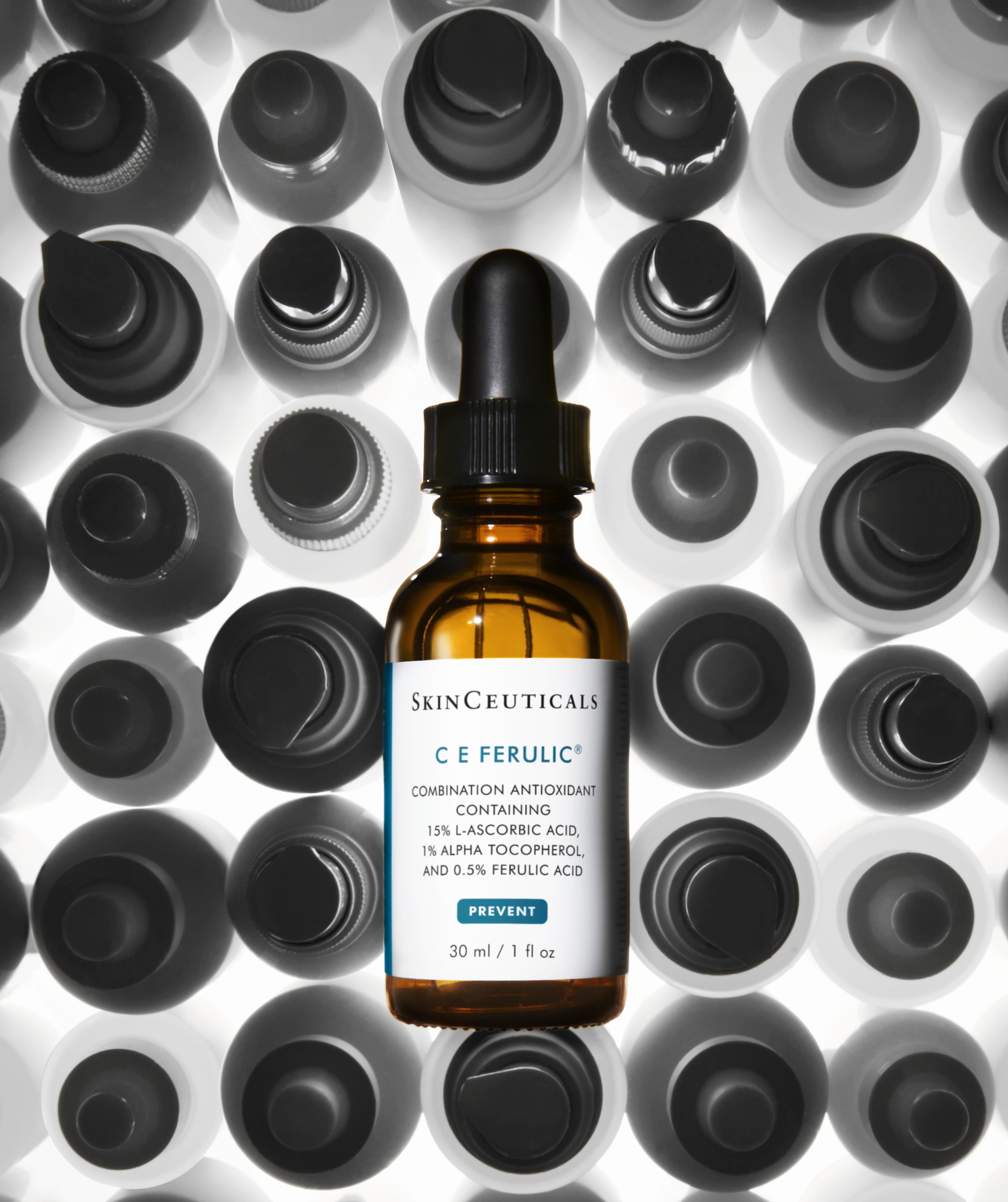 SkinCeuticals C E Ferulic antioxidant serum bottle with dropper displayed against black and white bottle cap background