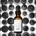 SkinCeuticals C E Ferulic antioxidant serum bottle with dropper displayed against black and white bottle cap background
