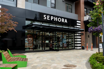 Sephora retail storefront with black and white striped awning, glass entrance, and modern urban plaza setting