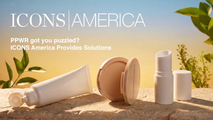 Skincare and cosmetics product collection displayed on sand with green foliage and natural lighting