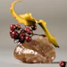 Yellow banana peel and red rowan berries arranged on a textured stone against gray background