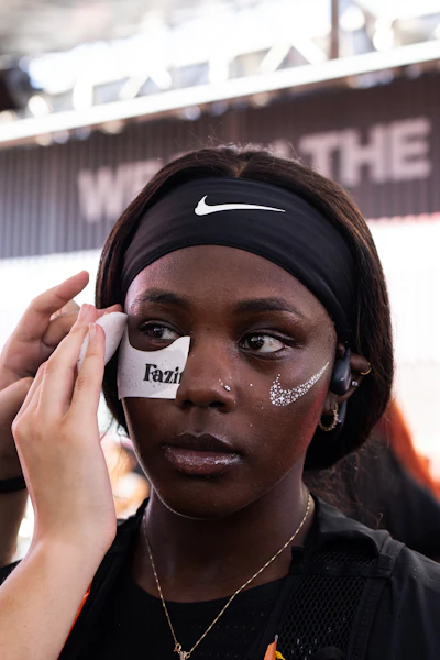 Athlete wearing Nike headband with glitter eye makeup at outdoor stadium