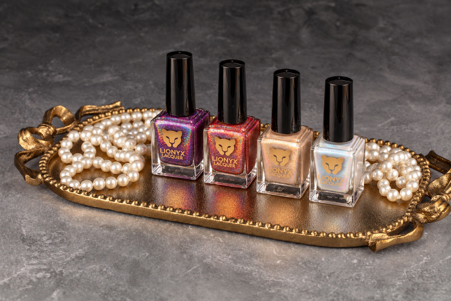 Lionyx nail polish collection displayed on gold tray with pearl beads, featuring four bottles in purple, red, nude, and white shades