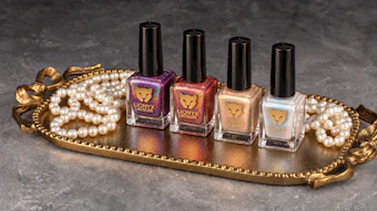Lionyx nail polish collection displayed on gold tray with pearl beads, featuring four bottles in purple, red, nude, and white shades